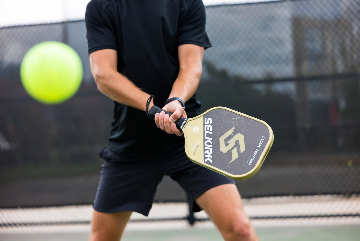 Player hitting a shot with the Selkirk LUXX Control Air pickleball paddle on an outdoor court